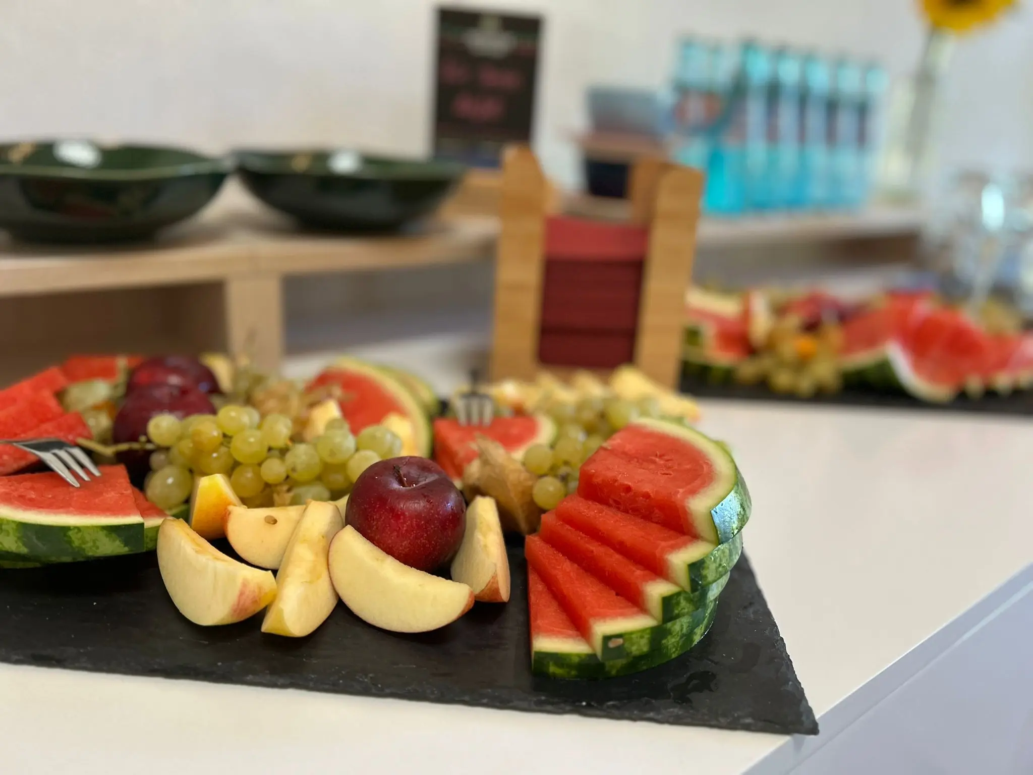 Detailaufnahme einer frischen Obstplatte mit Wassermelone, Weintrauben und Äpfeln.