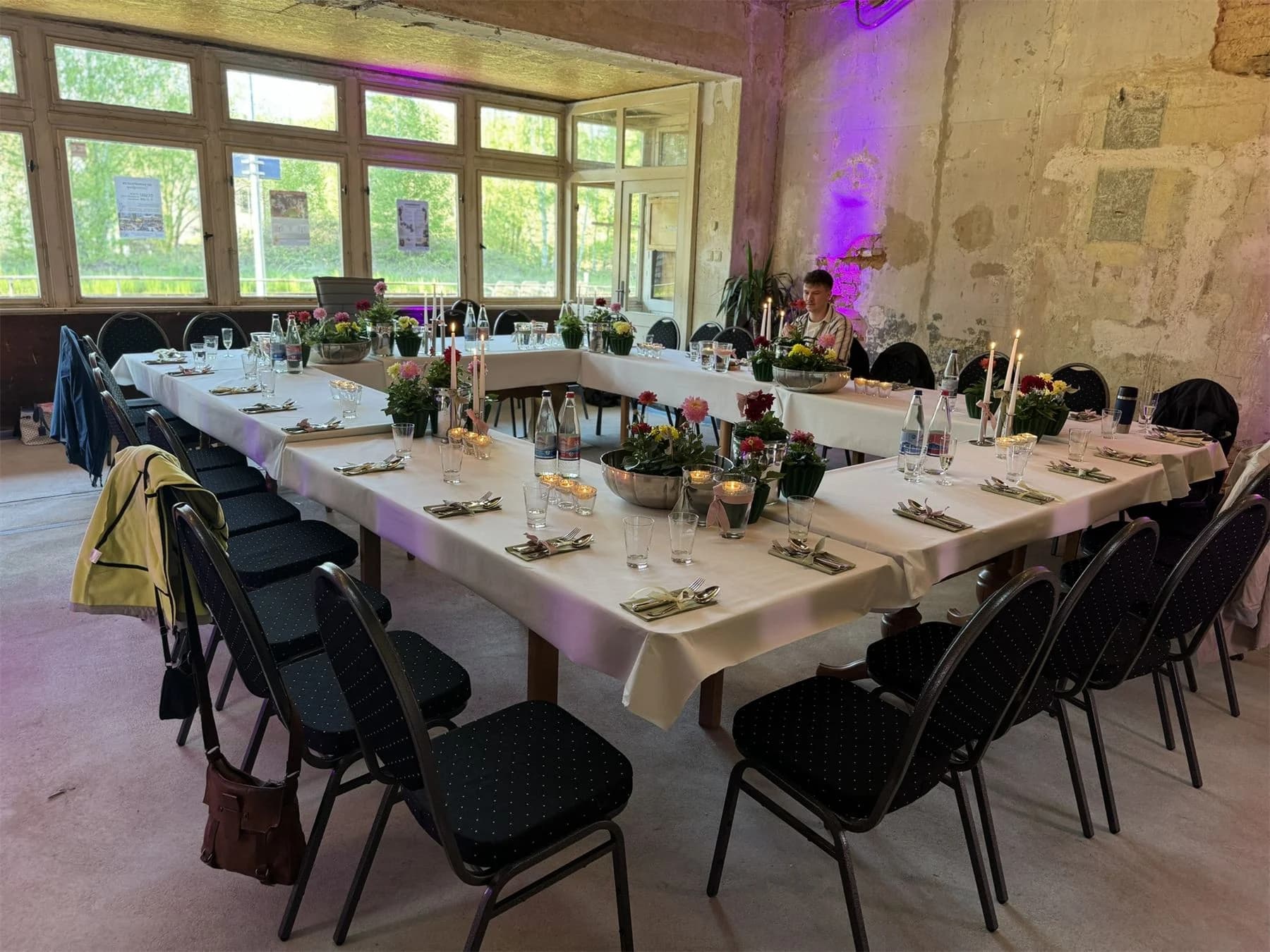 Tischdekoration mit Blumen und Kerzen in U-Form